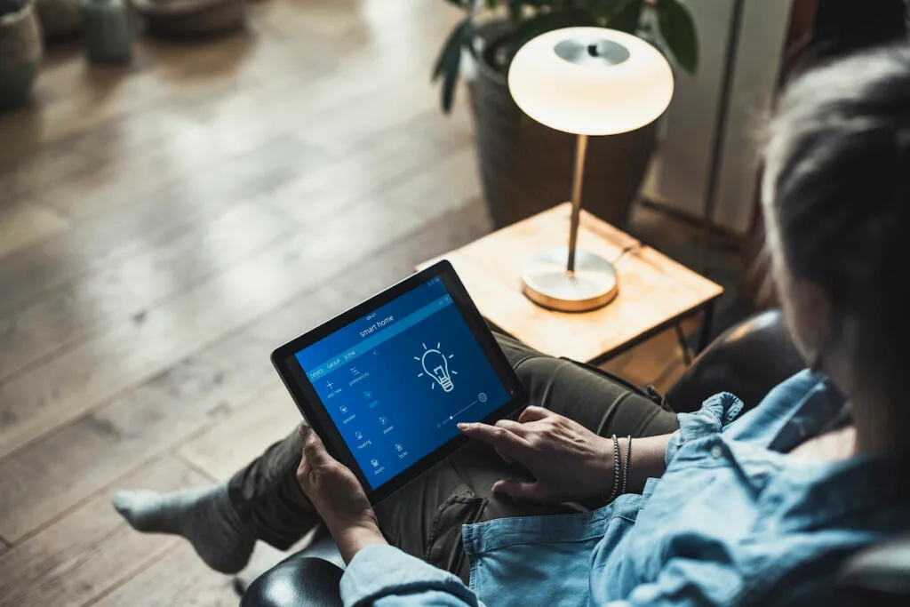 Woman using digital tablet while sitting in living room